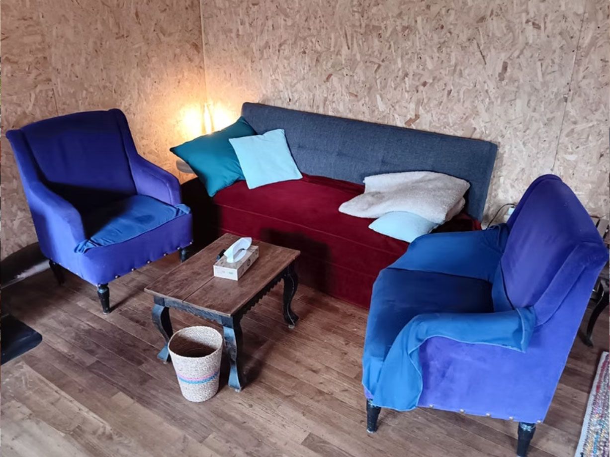 Espace d’accompagnement individuel avec fauteuils, canapé et table dans une ambiance chaleureuse